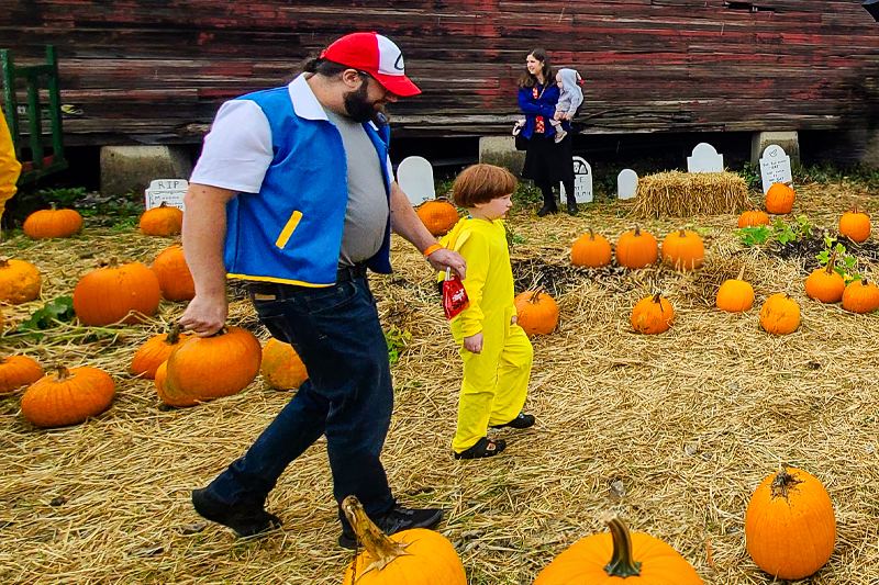 A dad and his son in Halloween costumes walking through the pumpkin patch at the Ohio Railway Museum's Pumpkin Patch Express